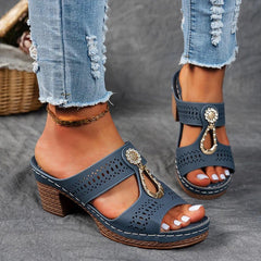 Navy perforated slide sandals with decorative charm strap and chunky block heel