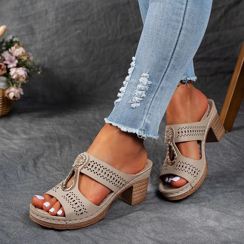 Beige perforated slide sandals with decorative tassel charm and block heel