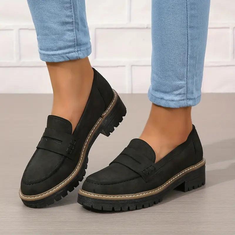 Black comfort loafers, slip-on style with buckle bar and thick tread sole
