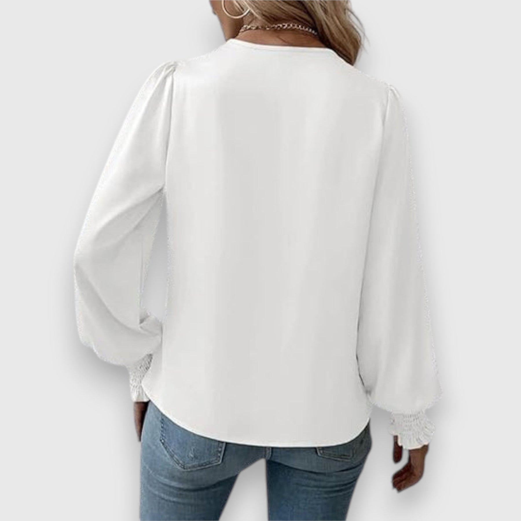 White long-sleeve satin blouse, back view with draped fabric and gathered cuffs