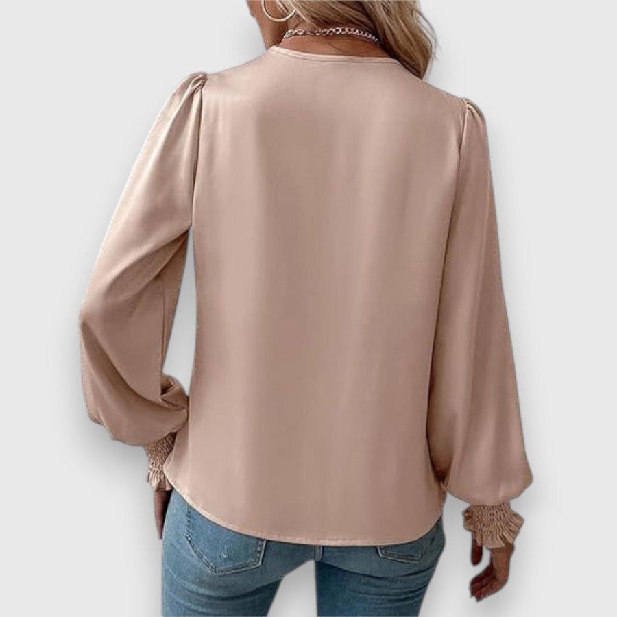 Beige long-sleeve satin blouse, back view with draped neckline and gathered cuffs