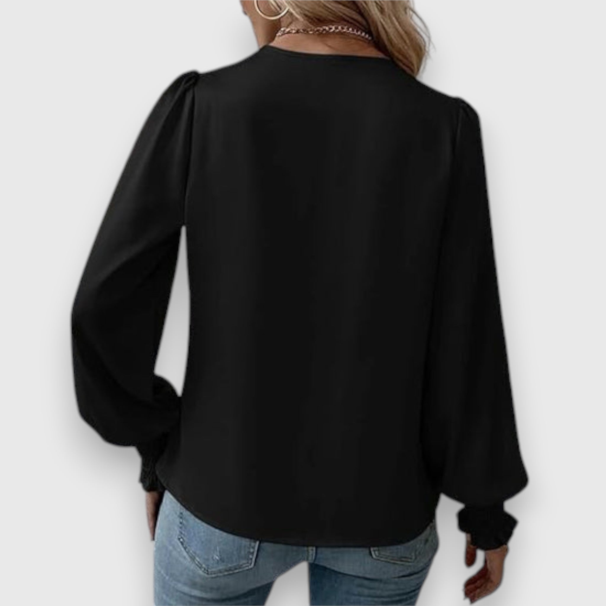 Black long-sleeve satin blouse, back view with loose drape and elasticized cuffs