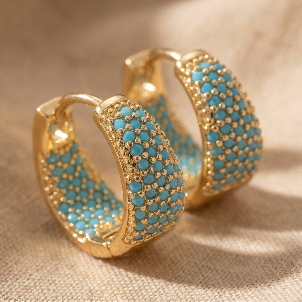 Gold-tone hoop earrings with turquoise beaded lattice design, textured front