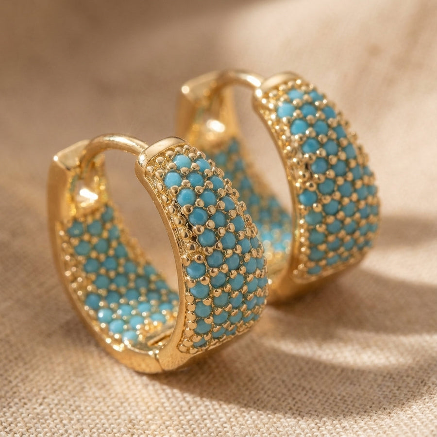 Gold-tone hoop earrings with turquoise beaded lattice design, textured front