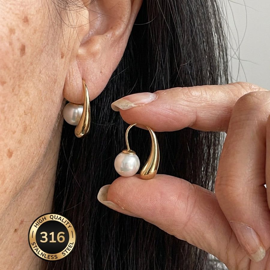 Gold-tone arc hoop earrings with small white pearl drops, minimalist design