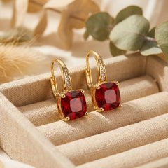 Gold hoop earrings with red square gemstones and small clear stones
