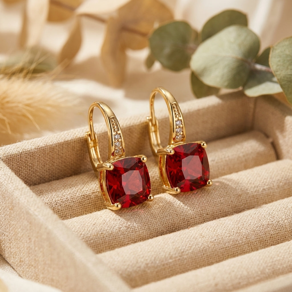 Gold hoop earrings with red square gemstones and small clear stones