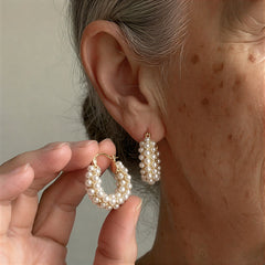 Layered pearl hoop earrings, close-up on ear with tiered white pearl beads