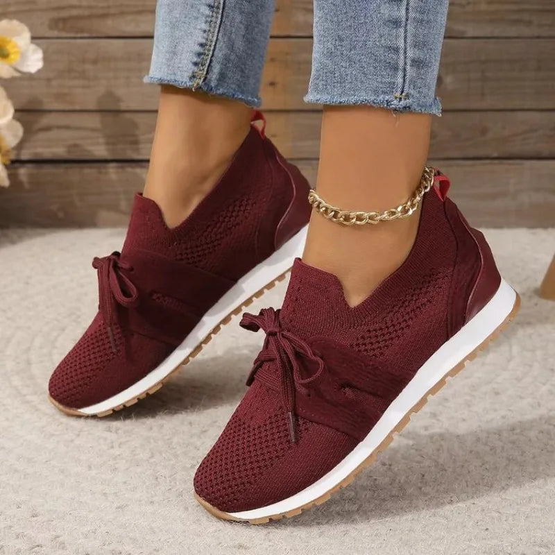 Burgundy red comfort sneakers with lace ties and knit upper with white sole.